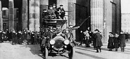 Revolutionäre Soldaten mit der Roten Fahne am 9. November vor dem Brandenburger Tor. Bundesarchiv, Bild 183-B0527-0001-810 / Unbekannt / CC-BY-SA 3.0