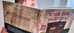 DAs Foto zeigt den Sohn der Autorin, der mit einem Auge über das ausgeschlagene Buch hinweg blickt